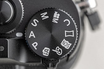 Close-up of camera mode dial with photography settings
