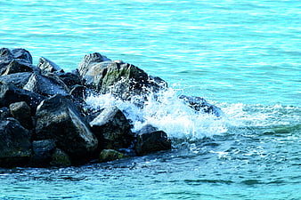 Ocean Waves Crashing Against Dark Rocks