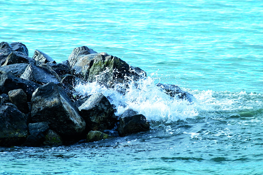Ocean Waves Crashing Against Dark Rocks