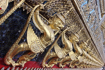 Golden mythical guardian figures on ornate temple architecture