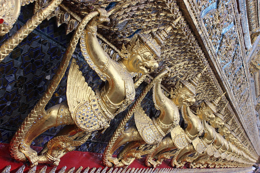 Golden mythical guardian figures on ornate temple architecture