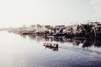 Floating village on river with boat and stilt houses