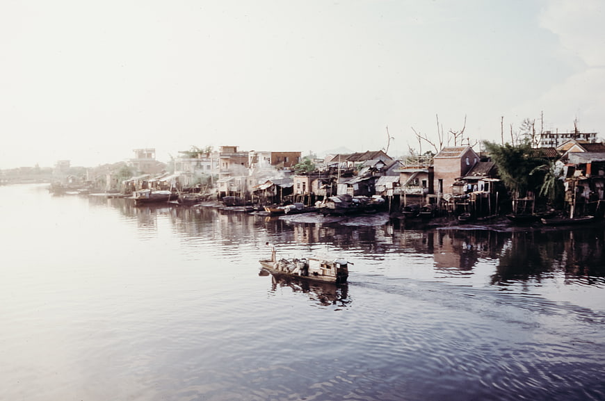 Floating village on river with boat and stilt houses