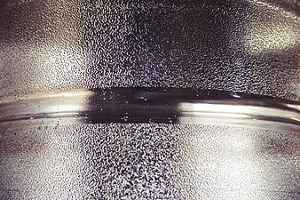 Close-up of textured metal surface with condensation droplets