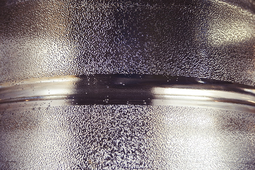 Close-up of textured metal surface with condensation droplets