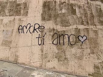 Handwritten 'Amore ti amo' graffiti on weathered concrete wall