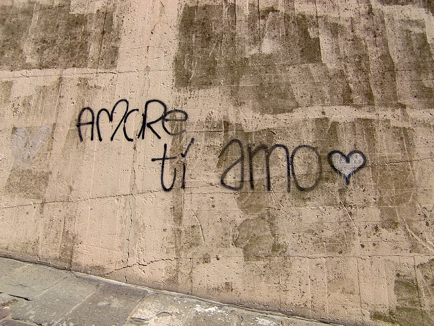 Handwritten 'Amore ti amo' graffiti on weathered concrete wall
