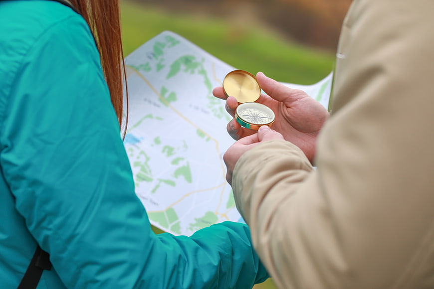 Couple Using Compass and Map for Hiking Navigation