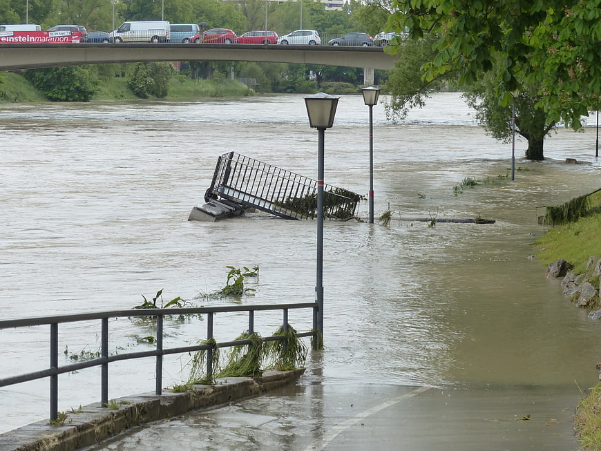Severe River Flooding With Submerged Railings And Bridge Traffic