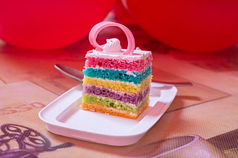 Colorful Rainbow Cake Slice on White Plate with Red Balloons