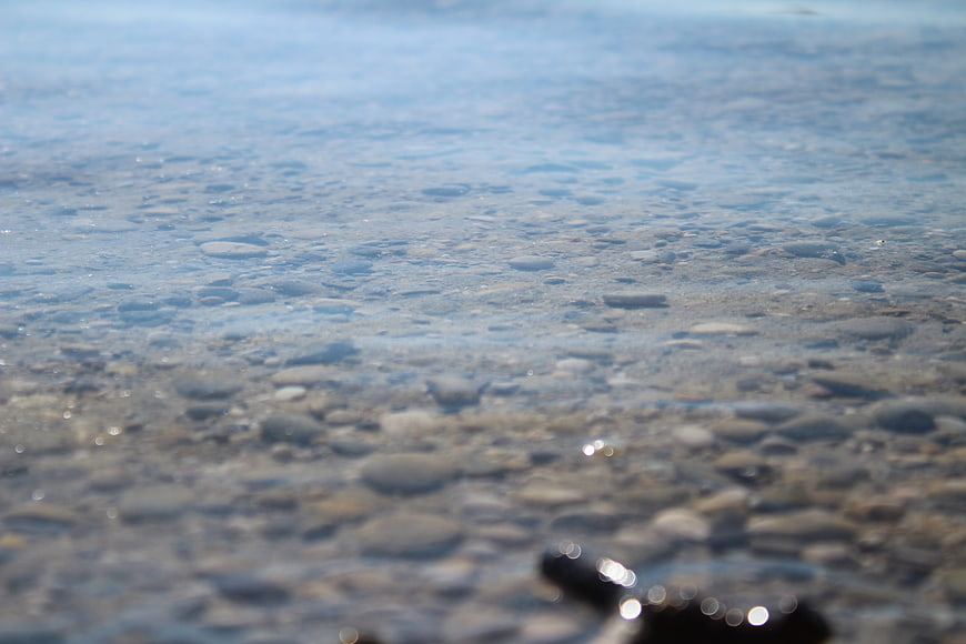 Clear Blue Water Over Smooth Pebbles on Lake Bottom