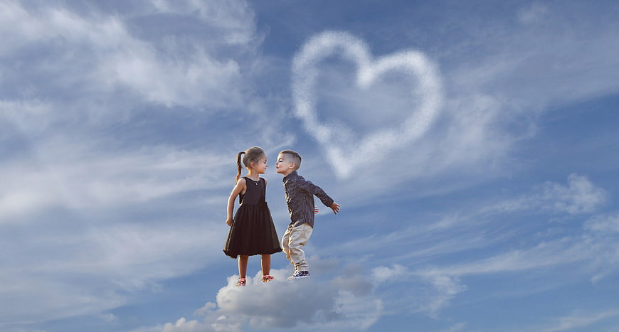 Cute children standing on cloud with heart shape in sky