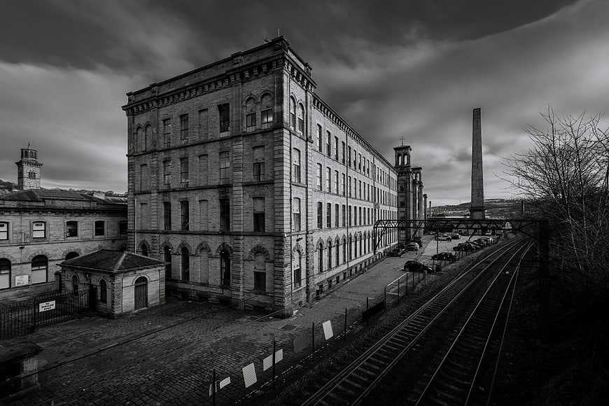 Black and white photo of historic textile mill and railway tracks
