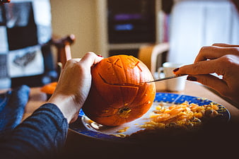 Hands Carving Halloween Pumpkin with Knife