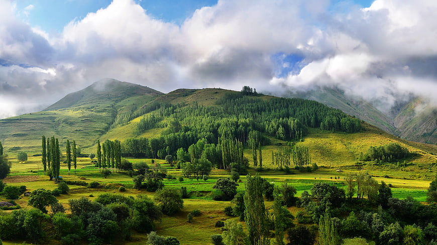 Lush Green Mountain Valley with Clouds and Trees
