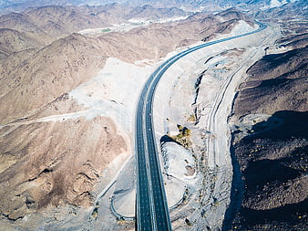 Aerial View of Winding Highway Through Arid Desert Mountains