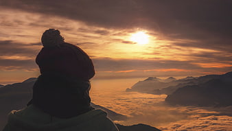 Silhouette of Hiker Watching Mountain Sunset Above Clouds