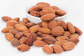 Roasted Salted Almonds Spilling from White Bowl