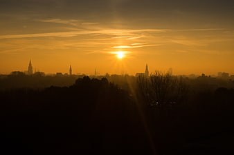 Golden Sunrise Over Silhouetted City Skyline