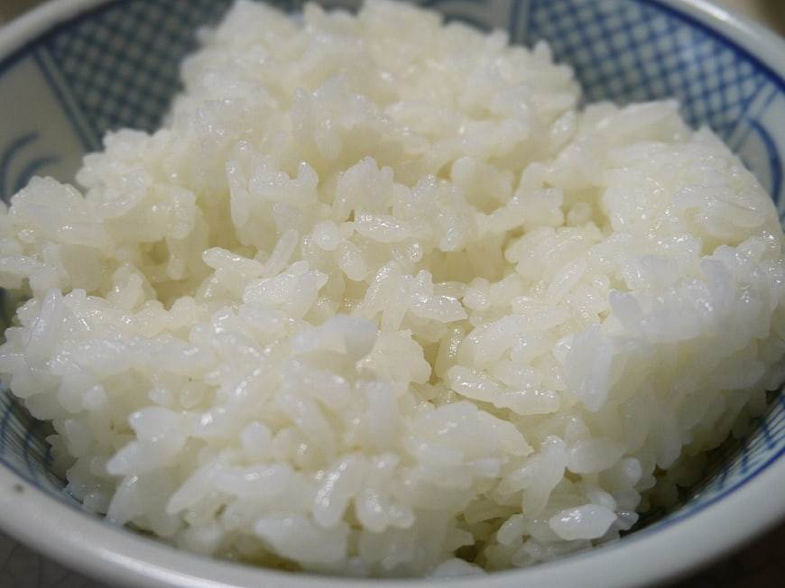 Close-up of steamed white rice in a blue patterned bowl