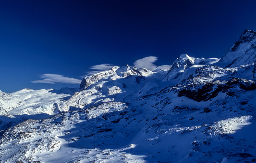 Snowy Mountain Peaks Under Deep Blue Sky