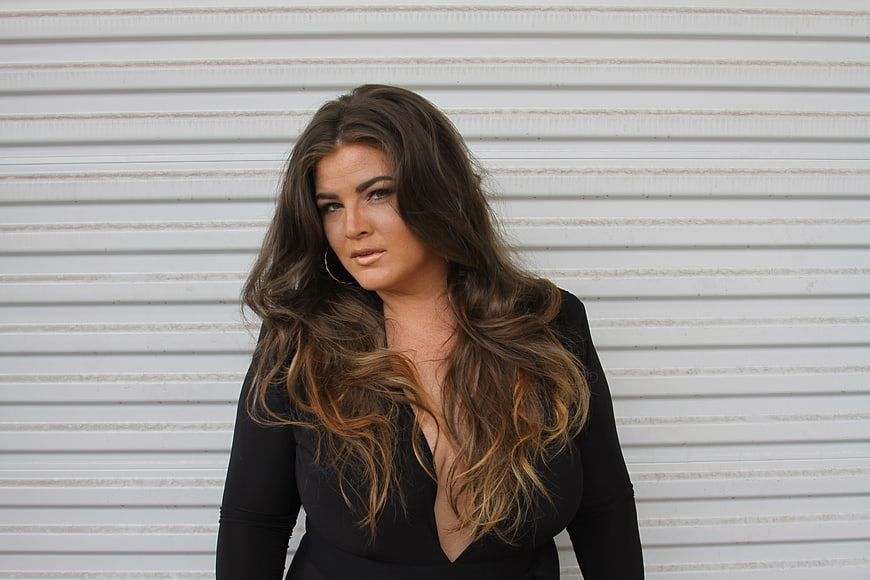 Confident Brunette Woman Portrait Against White Wall