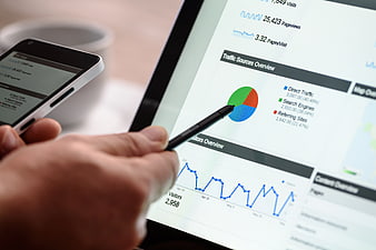 Hand Using Stylus on Tablet Analytics Dashboard