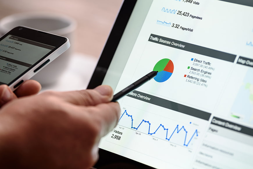 Hand Using Stylus on Tablet Analytics Dashboard
