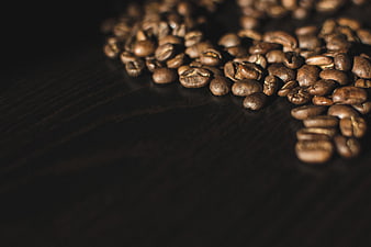 Roasted coffee beans on dark wood background