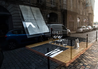 Restaurant table setting viewed through window with street reflection
