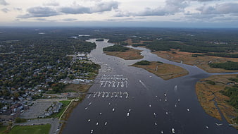 Aerial view of coastal harbor with boats and marshland