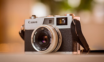 Vintage Canon Film Camera with 40mm Lens on Wooden Surface