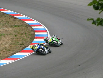 Two Motorcyclists Racing on a Curved Track