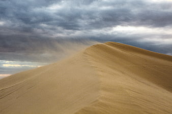 Dramatic Sand Dune Ridge Under Stormy Clouds
