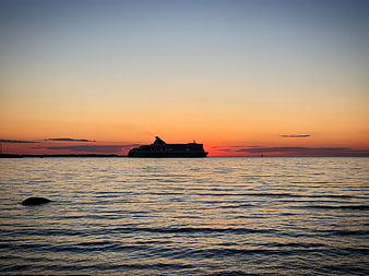 Ferry Silhouette on Calm Ocean at Sunset
