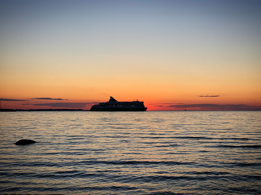 Ferry Silhouette on Calm Ocean at Sunset