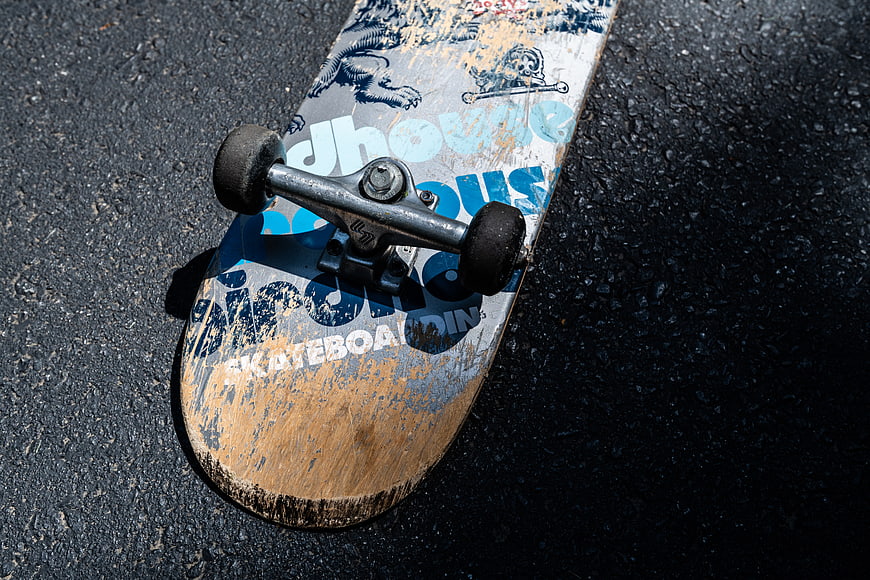 Worn Skateboard Deck on Asphalt Pavement