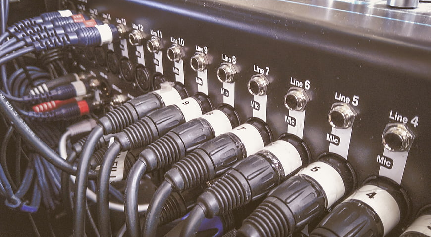 Close-up of audio mixer with connected XLR microphone cables