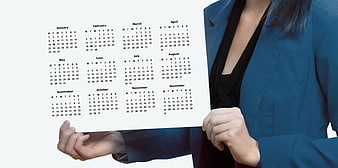 Businesswoman holding blank annual calendar schedule