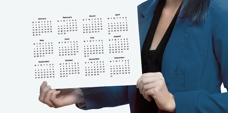 Businesswoman holding blank annual calendar schedule