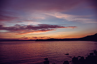 Dramatic purple and orange sunset over calm ocean water