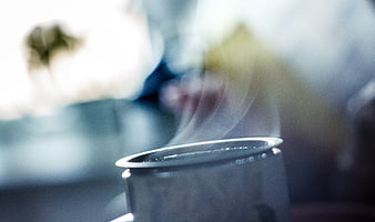 Close-up of steaming hot coffee cup with blurred background