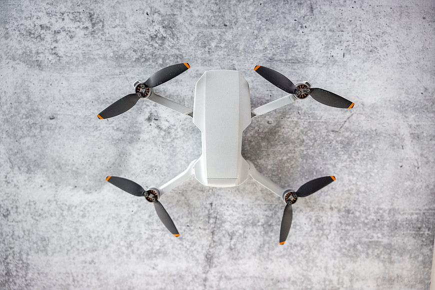 Top view of white quadcopter drone on concrete background
