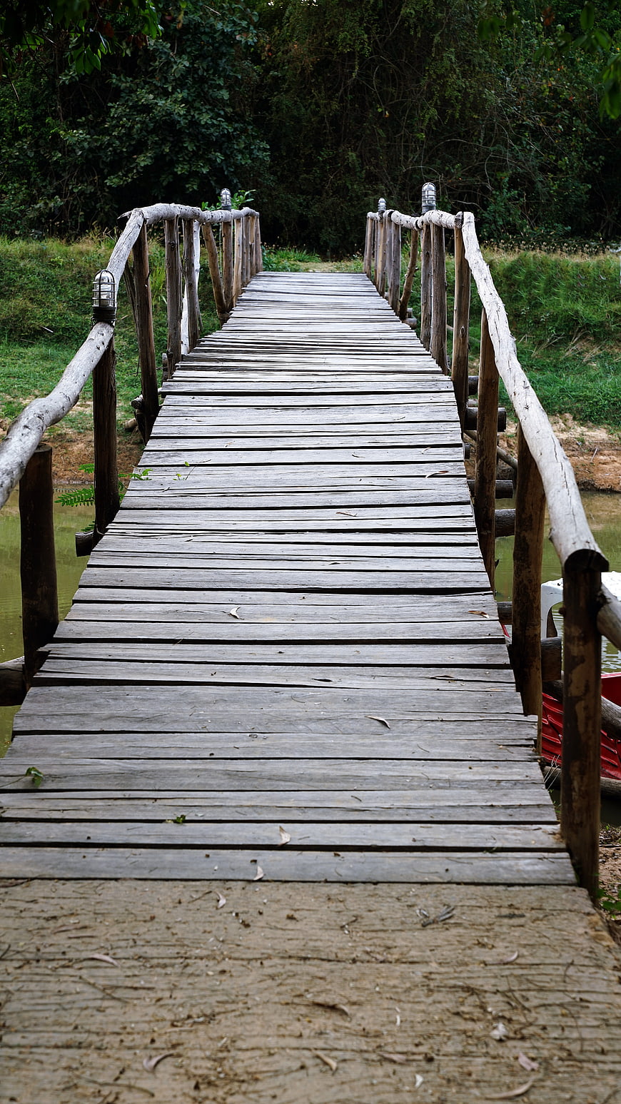 Rustic Wooden Bridge Over River in Lush Forest
