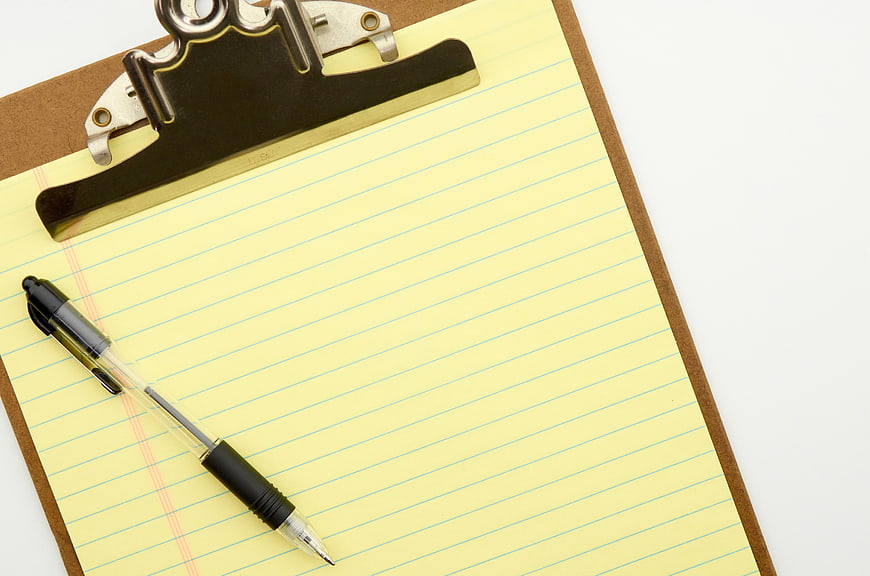 Yellow Lined Paper on Clipboard with Pen