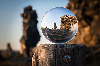 Crystal ball reflecting sandstone rock formation at sunset