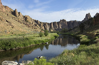 Scenic river winding through rocky mountain canyon with reflections