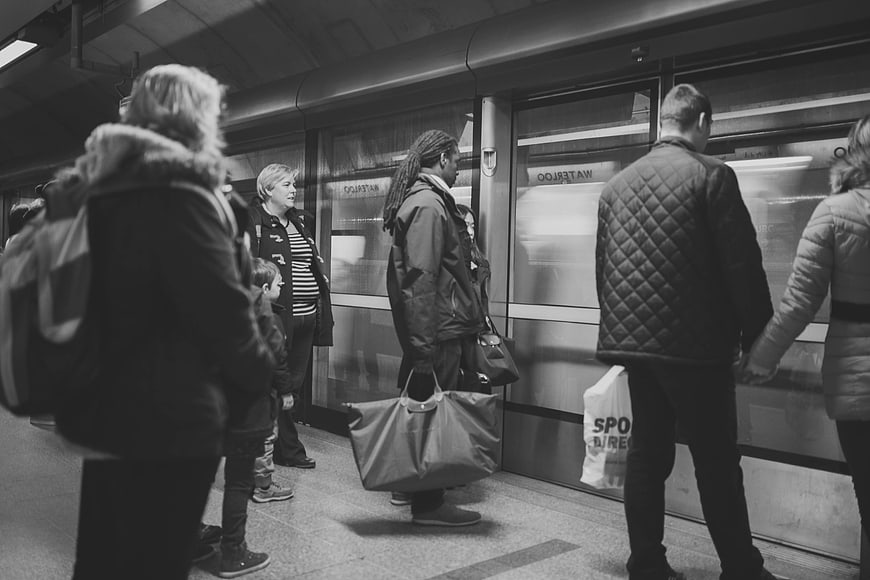 Black and white commuters waiting at subway platform