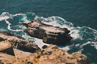 Aerial View of Turquoise Waves Crashing on Rocky Coastline