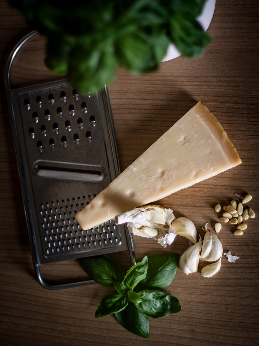Pesto ingredients with parmesan cheese, garlic, basil, and pine nuts